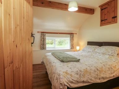 A bedroom with a bed and window at Bryn Eithin in Penygroes