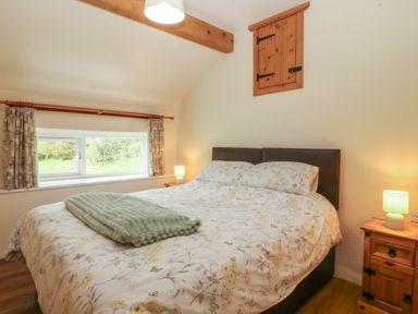 A bedroom with a bed and window at Bryn Eithin in Penygroes