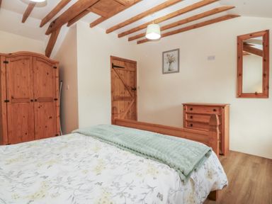 A bedroom with wooden furniture at Bryn Eithin in Penygroes