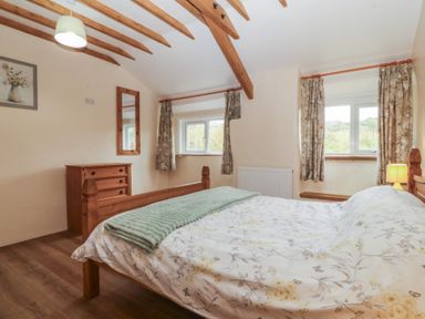 A bedroom with a bed and dresser at Bryn Eithin in Penygroes