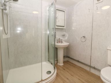A bathroom with a shower, sink, and toilet at Bryn Eithin Penygroes