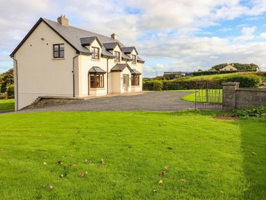 A house with a driveway and grass at Wild Atlantic Ferry View, Kilrush, County Clare