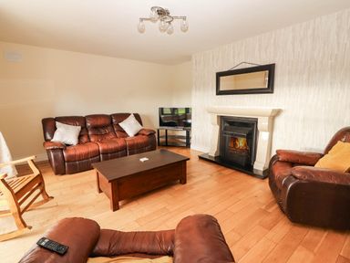 A living room with a fireplace and television at Wild Atlantic Ferry View in Kilrush, County Clare
