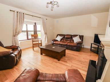 A living room with a sofa and coffee table at Wild Atlantic Ferry View in Kilrush, County Clare
