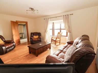 A living room with a coffee table and leather sofas at Wild Atlantic Ferry View, Kilrush, County Clare
