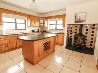 A kitchen with wooden cupboards and a stove at Wild Atlantic Ferry View in Kilrush, County Clare
