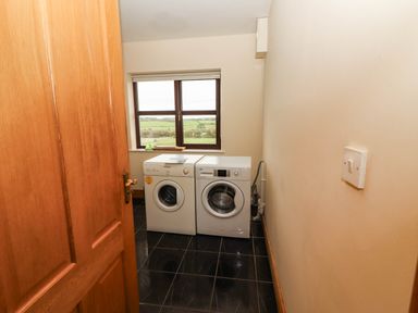 A laundry room with a washing machine and tumble dryer at Wild Atlantic Ferry View Kilrush, County Clare
