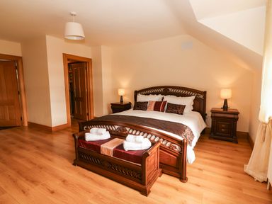 A bedroom with a bed and nightstands at Wild Atlantic Ferry View, Kilrush, County Clare