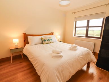 A bedroom with a bed and lamps at Wild Atlantic Ferry View in Kilrush, County Clare