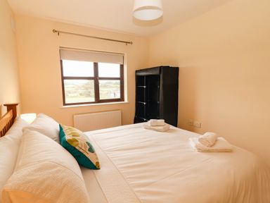 A bedroom with a bed and a shelf at Wild Atlantic Ferry View, Kilrush, County Clare