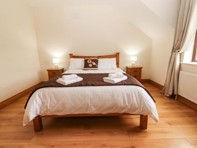 A bedroom with a bed and nightstands at Wild Atlantic Ferry View, Kilrush, County Clare
