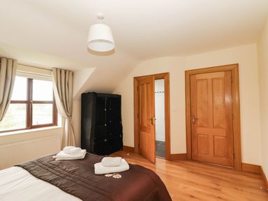 A bedroom with a bed and window at Wild Atlantic Ferry View in Kilrush, County Clare