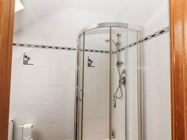 A shower cubicle with tiles and a radiator at Wild Atlantic Ferry View, Kilrush, County Clare