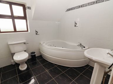 A bathroom with a toilet, bathtub, and sink at Wild Atlantic Ferry View, Kilrush, County Clare
