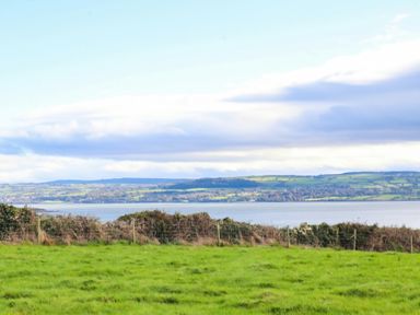 A landscape view of a body of water surrounded by hills and grass at Wild Atlantic Ferry View in Kilrush, County Clare