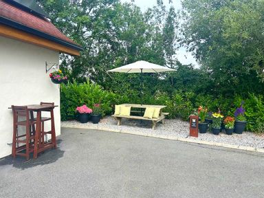 An outdoor seating area with a bench and umbrella at Limavady Cherry Tree Apartment, Sleeps 2 and Parking in Limavady