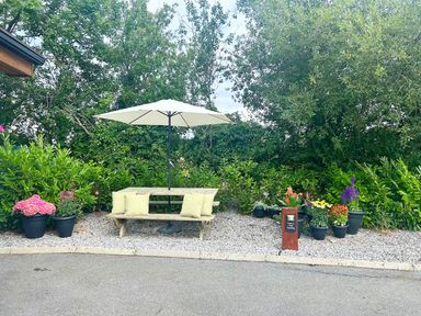 A table with benches and an umbrella in a garden at Limavady Cherry Tree Apartment, Sleeps 2 and Parking, Limavady