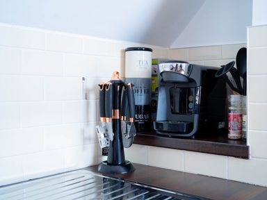 A kitchen countertop with knives, a coffee maker, and jars at Limavady Cherry Tree Apartment, Sleeps 2 and Parking in Limavady