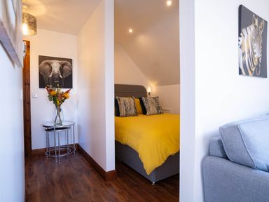 A bed with yellow bedding and a nightstand in a bedroom at Limavady Cherry Tree Apartment, Sleeps 2 and Parking, Limavady