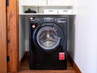 A washing machine and storage boxes in a laundry room at Limavady Cherry Tree Apartment, Sleeps 2 and Parking, Limavady