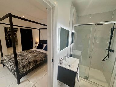 A bedroom with a bed and a bathroom with a sink and shower at Jeannies retreat at little lake fb