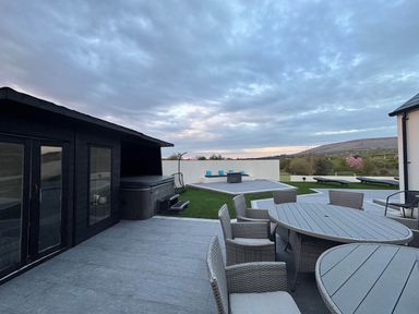 A patio with a hot tub and seating at Jeannies retreat at little lake fb
