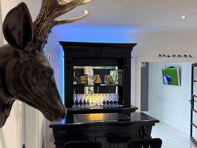 A bar with stools and a decorative deer head at Jeannies retreat at little lake fb