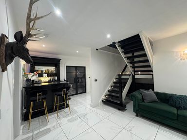 A living room with a bar and staircase at Jeannies retreat at little lake fb