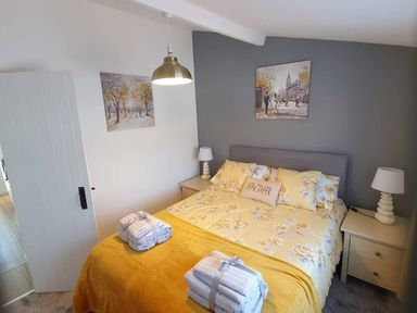A bedroom with a bed and bedside tables at 1 Bedroom Apartment with Sea View in Mevagissey