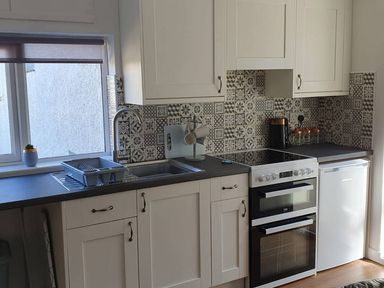 A kitchen with sink, stove, and refrigerator at 1 Bedroom Apartment with Sea View in Mevagissey