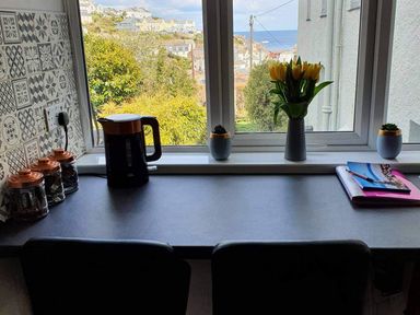 A kitchen with a kettle and flowers on the countertop at 1 Bedroom Apartment with Sea View in Mevagissey