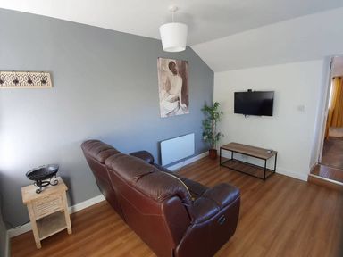 A living room with a sofa, table and television at 1 Bedroom Apartment with Sea View in Mevagissey