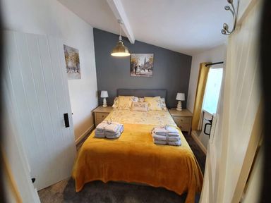 A bedroom with a bed and nightstand at 1 Bedroom Apartment with Sea View in Mevagissey