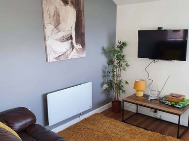 A living room with a television and a coffee table at 1 Bedroom Apartment with Sea View in Mevagissey