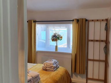 A bedroom with a bed and towels at 1 Bedroom Apartment with Sea View in Mevagissey