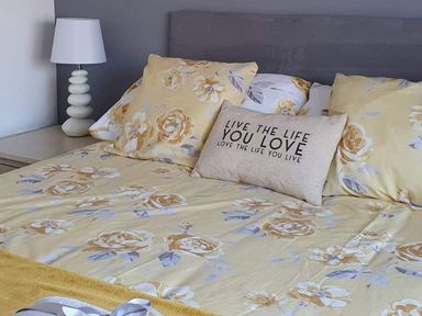 A bedroom with a bed, lamp, and decorative pillow at 1 Bedroom Apartment with Sea View in Mevagissey