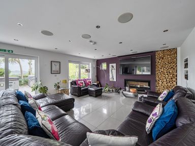 A living room with sofas and a television at 5 Bed House, Sleeps 14 with Hot Tub and Bar in Tavistock