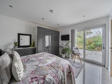 A bedroom with a large bed and wardrobe at 5 Bed House, Sleeps 14 with Hot Tub and Bar in Tavistock