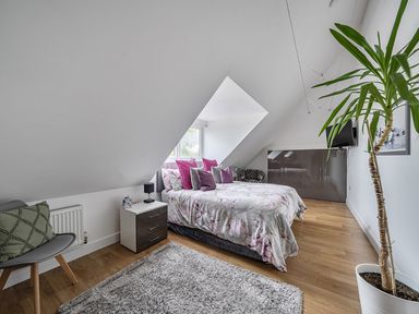 A bedroom with a bed and a plant at 5 Bed House, Sleeps 14 with Hot Tub and Bar in Tavistock