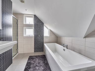 A bathroom with a bathtub and shower at 5 Bed House, Sleeps 14 with Hot Tub and Bar, Tavistock