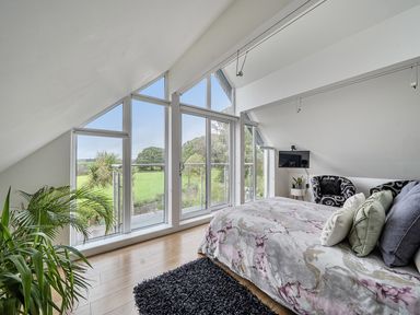 A bedroom with a bed and a television at 5 Bed House, Sleeps 14 with Hot Tub and Bar in Tavistock