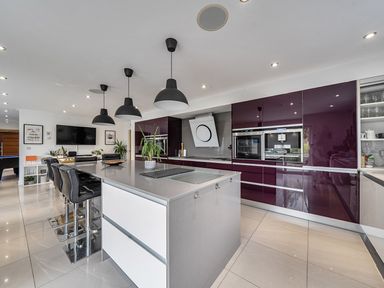 A kitchen with bar stools and a kitchen island at 5 Bed House, Sleeps 14 with Hot Tub and Bar Tavistock