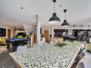 A dining room with a large table and pool table at 5 Bed House, Sleeps 14 with Hot Tub and Bar Tavistock