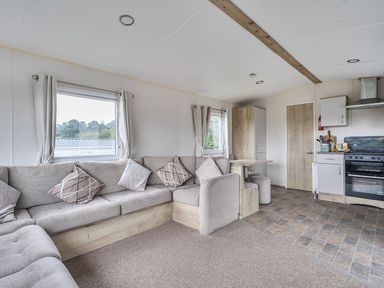 A living room with a sofa and kitchen unit at Ty dee seaview escapes in Looe