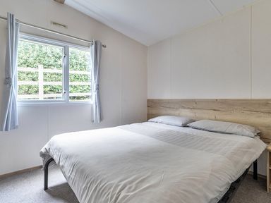 A bedroom with a bed and window at Ty dee seaview escapes in Looe