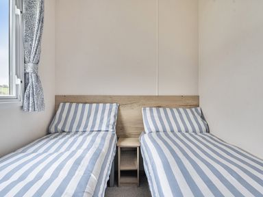 A bedroom with two single beds and a window at Ty dee seaview escapes in Looe