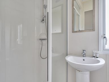 A bathroom with a shower and sink at Ty dee seaview escapes in Looe