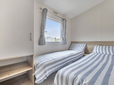 A bedroom with two single beds and a window at Ty dee seaview escapes in Looe