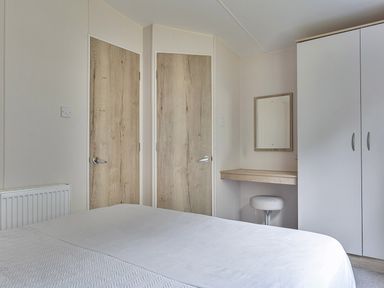 A bedroom with a bed and a table at Ty dee seaview escapes in Looe