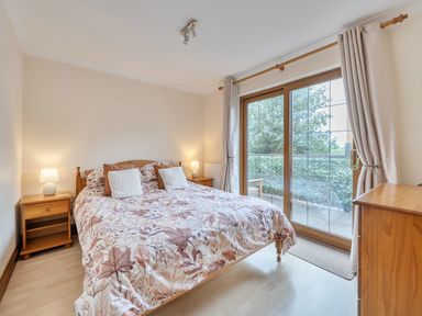 A bedroom with a bed and windows at 2 Bed, Sleeps 4 with Parking and EV charging in Wadebridge